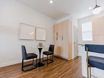 a dining area with a small table and two chairs and a kitchenette in the background at The Austin Townhomes, Draper, 84020